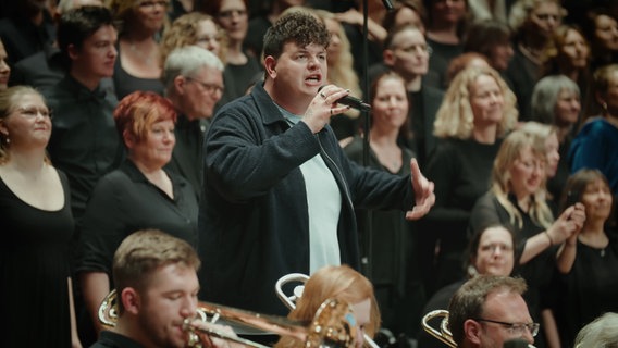 Isaak singt mit einem Orchester und mehreren Chören in Lübeck. © NDR Foto: Screenshot