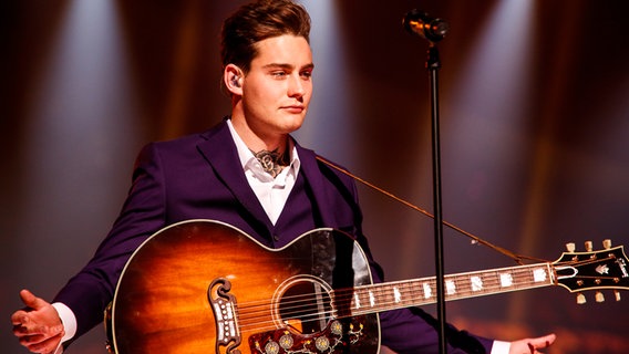 Douwe hält seine Gitarre und blickt nachdenklich. © eurovision.tv Foto: Thomas Hanses