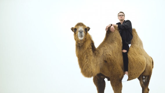 Mikolas Josef, der tschechische Kandidat für den Eurovision Song Contest 2018, sitzt auf einem Kamel. © Czech TV 
