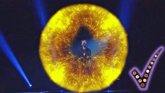Der litauische Sänger Jurijus steht in einem Feuerball auf der Bühne und singt.  