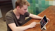 Lissabjörn ist vor einem Tablet  