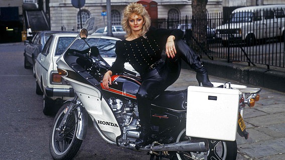 Die Sängerin Bonnie Tyler auf einem Motorrad - eine Aufnahme aus dem Jahr 1983. © picture alliance /Photoshot Foto: dpa / Photoshot