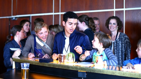 Basim spricht beim deutschen Botschaftsempfang mit einem kleinen Jungen © NDR Foto: Rolf Klatt