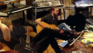 Xavier Darcy sitzt mit seiner Gitarre im Studio auf dem Boden. © Screenshot 