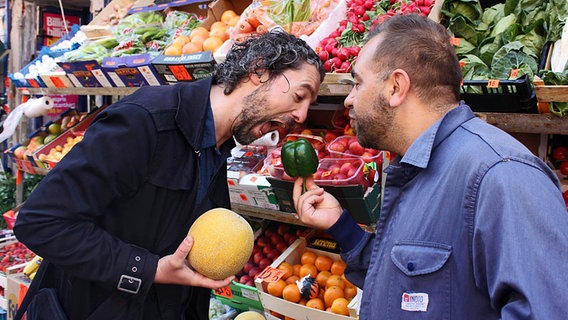Edin Bahtijaragic und Gabriel Coronel albern vor einem Gemüsestand herum. © NDR Foto: Kathrin Otto