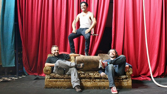 Gabriel Coronel, Hugo Coronel und Edin Edin Bahtijaragic (von links nach rechts) sitzen in ihrem Probenraum. © NDR Foto: Kathrin Otto