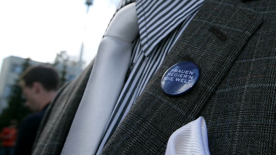 Ein Ansteckbutton mit dem deutschen ESC-Titel von Roger Cicero: "Frauen regier'n die Welt". © NDR Foto: Rolf Klatt