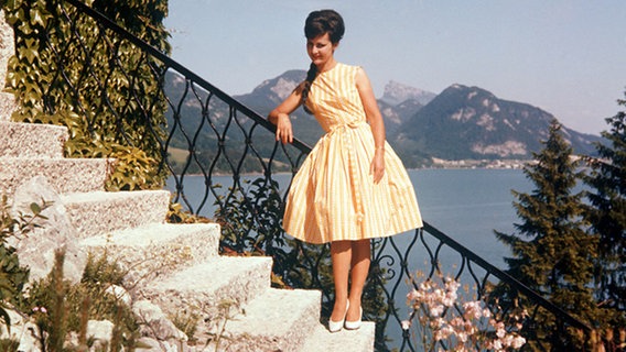 Ein Model posiert in Italien, in einem Kleid mit engem Oberteil und weitem Rock - gestützt von einem Petticoat. © dpa picture-alliance 