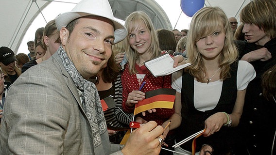 Roger Cicero verteilt in Helsinki Autogramme an seine Fans. © dpa Foto: Jörg Carstensen