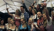 Die Mitglieder von voXXclub feiern mit weiblichen Fans in einem Bierzelt  