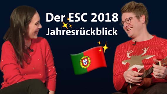 Alina Stiegler (li.) und Stefan Spiegel lachen sich an, gekleidet in rote Weihnachtspullis.  