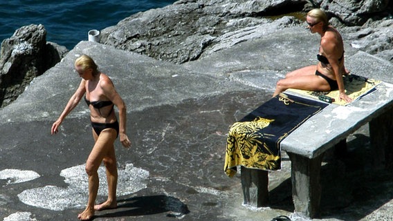 Alice und Ellen Kessler in Bikinis an einem Felsstrand. © dpa - Fotoreport Foto: LaPresse Riccio