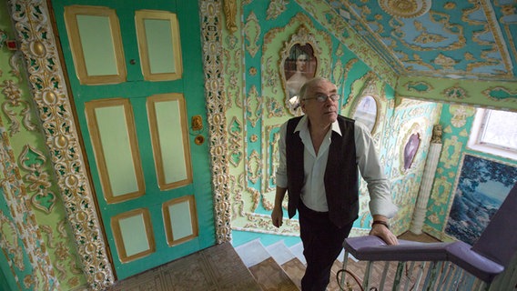 Der Pensionär Vladimir Chaika geht durch den Flur eines privaten Wohnhauses in der ukrainischen Hauptstadt Kiew, den er selbst bemalt hat © dpa 