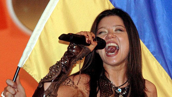 Ruslana singt nach ihrem Sieg beim Grand Prix 2004 in Istanbul vor der ukrainischen Flagge © Picture Alliance Foto: Ulrich Perrey