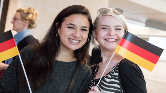 S!sters mit deutschen Fahnen im Flughafen. S!sters mit deutschen Fahnen im Flughafen. © NDR Foto: Claudia Timmann