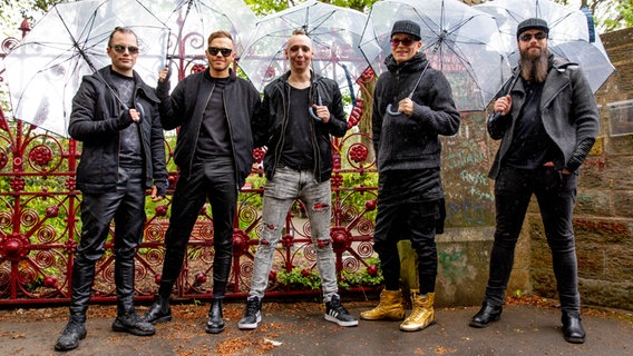 Die fünf Bandmitglieder von Lord Of The Lost mit Regenschirmen. © NDR Foto: Claudia Timmann