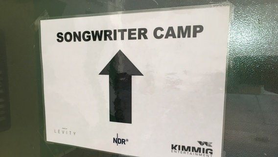 Ein Schild mit einem Pfeil, der den Weg zum Song Writer Camp deutet. © Marcel Stober 