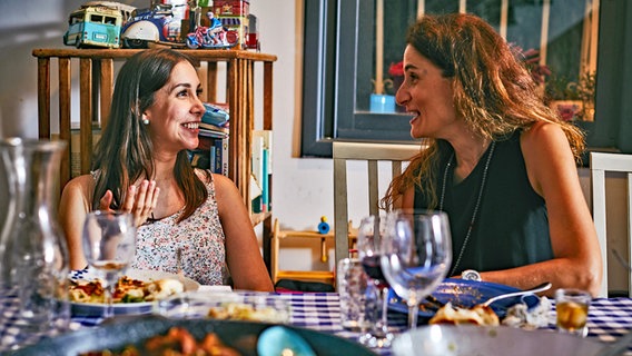 Zwei Frauen unterhalten sich angeregt beim Essen. © Amir Menahem 