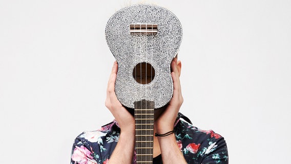 Jendrik Sigwart, Deutschlands Kandidat für den Eurovision Song Contest 2021, hält seine Ukulele vor sein Gesicht. © NDR 