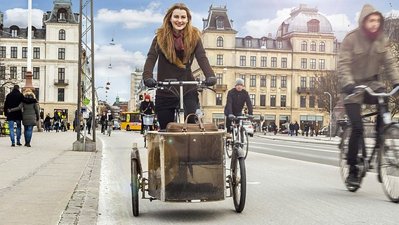 Die dänische Sängerin Emmelie de Forest auf einem Fahrrad mit einem Gepäckwagen. © ESC tv Foto: Michael Søndergaard