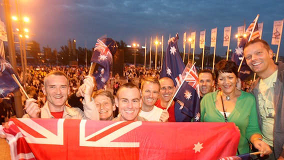 ESC-Fans aus Australien mit Australien-Fähnchen und einer großen Landesflagge. ESC-Fans aus Australien mit Australien-Fähnchen und einer großen Landesflagge. © NDR Foto: Rolf Klatt