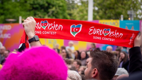 Fans mit Aserbaidschan-ESC-Schal und Nemo-Mütze im Eurovision Village. © NDR Foto: Margarita Ilieva