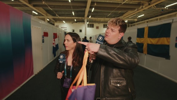 Isaak und Alina gehen backstage durch die Malmö Arena beim ESC 2024. © NDR Foto: Screenshots