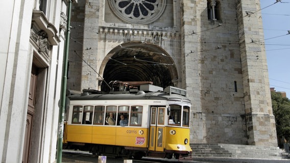 Eine gelbe Straßenbahn fährt durch Lissabon. © www.visitlisboa.com 