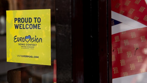 Ein Schild mit der Aufschrift "Proud to Welcome Eurovision Song Contest" klebt an einer Tür. © NDR Foto: Claudia Timmann