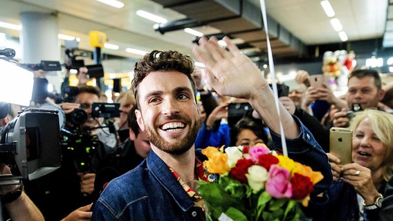 Der niederländische ESC-Gewinner Duncan Laurence grüßt in eine Menschenmenge. Der niederländische ESC-Gewinner Duncan Laurence grüßt in eine Menschenmenge. © picture alliance / ANP Foto: Robin van Lonkhuijsen