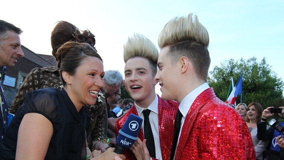 Jedward mit der Bloggerin Sandra Hoffmann auf dem roten Teppich.  