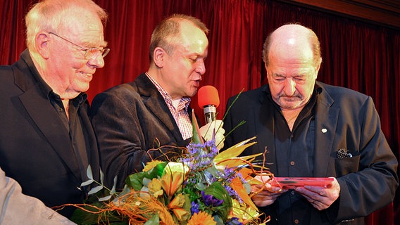 Der Komponist Ralph Siegel auf der Bühne mit dem Komponisten Christian Bruhn (links) und OGAE-Moderator Reinhard Ehret © NDR/Patricia Batlle 