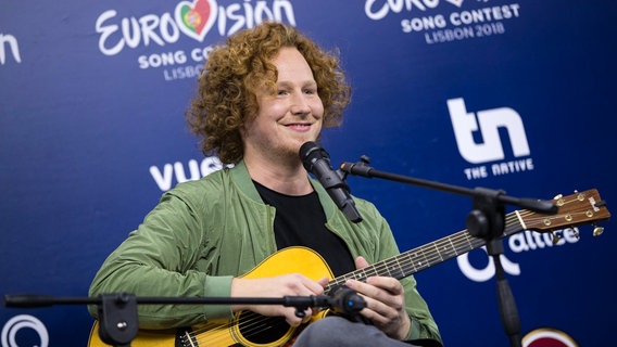 Michael Schulte mit Gitarre beim Pressegespräch in Lissabon. Michael Schulte mit Gitarre beim Pressegespräch in Lissabon. © NDR/ Rolf Klatt Foto: Rolf Klatt