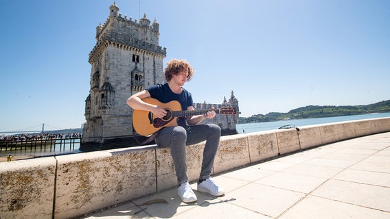 Michael Schulte spielt Gitarre am Turm vom Belém in Lissabon. © NDR / Rolf Klatt Foto: Rolf Klatt