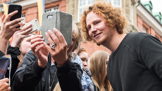 Michael Schulte, Viertplatzierter des Eurovision Song Contest, wird von Fans in seiner Heimatstadt empfangen und macht ein Selfie. © dpa Foto: Daniel Bockwoldt