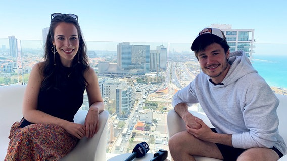 Alina Stiegler sitzt mit Miki auf einem Hotel-Balkon.  