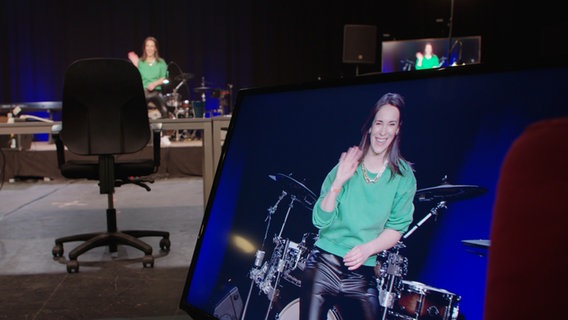 Ein Bildschirm mit der Moderatorin Alina Stiegler, wie sie auf einer Bühne steht und winkt. © NDR Foto: Screenshot