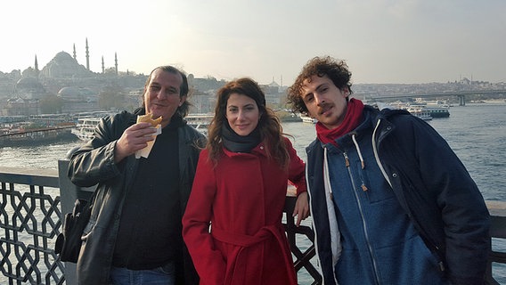 Serdar Yayla, Derya Kaptan und Joseph Simon stehen auf einer Brücke in Istanbul. © Meltem Kaptan Foto: Meltem Kaptan