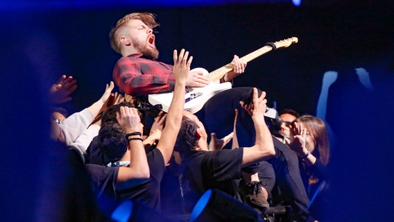 Gitarrist Dániel Kökényes von der Band AWS übt das Stagediving auf der Bühne in Lissabon. © eurovision.tv Foto: Andres Putting