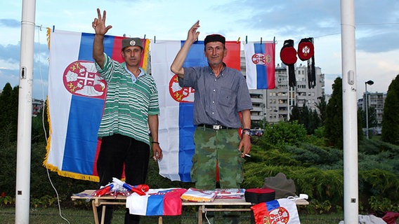 Zwei Männer verkaufen vor der Belgrad Arena serbische Fahnen und Hüte © NDR Foto: Rolf Klatt