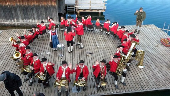 Eine Musikkapelle sitzt auf einem Steg in Weissensee im Kreis © ORF/WEST4MEDIA 