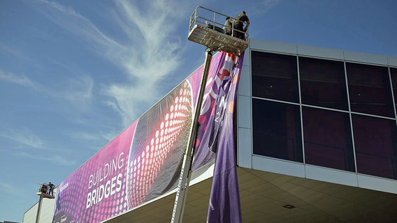 Draußen wird an der Halle die Eurovision-Bande angebracht © ORF/ H.M. Prainsack 