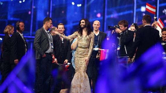 Die Sängerin Conchita Wurst hält einem Delegationsmitglied der österreichischen ESC-Delegation die Hand im Greenroom in Kopenhagen © NDR Foto: Rolf Klatt