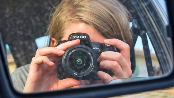 Antje Bracht fotografiert sich selbst im Rückspiegel. © NDR 
