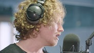 Michael Schulte singt in ein Mikrofon  