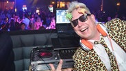 DJ Sunshine mit Leopardenjacke, Kopfhörer und Sonnenbrille  