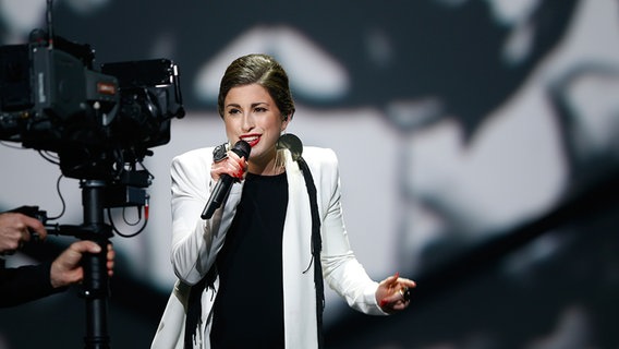 Ann Sophie steht auf der Bühne beim deutschen ESC-Vorentscheid und singt einer Fernsehkamera zugewandt ins Mikro. © NDR Foto: Rolf Klatt