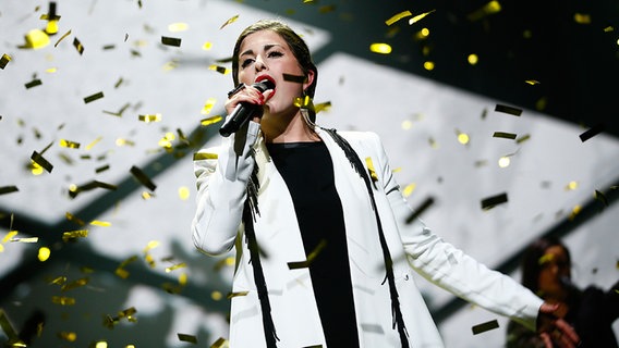 ESC-Kandidatin Ann Sophie singt in ein Mikrofon, während goldenes Konfetti auf sie herunter regnet. © NDR Foto: Rolf Klatt