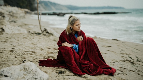 Victoria Georgieva, Bulgariens Kandidatin für den ESC 2020 in Rotterdam, in eine Decke gewickelt am Strand.  Foto: BNT