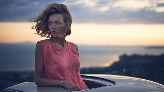 Sängerin Ella Endlich guckt aus einem offenen Autodach heraus. © Warner Music 